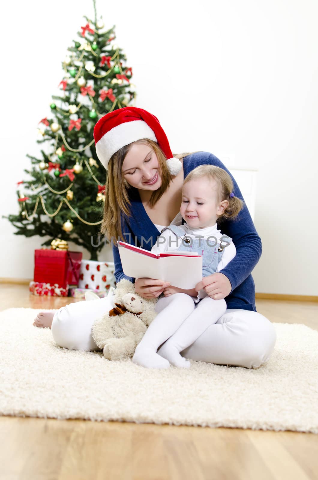 Girl and her mom reading book at Christmas