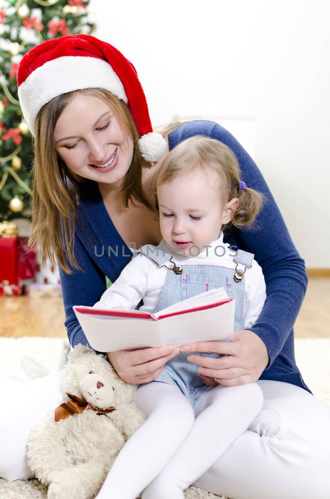 Girl and her mom reading book at Christmas