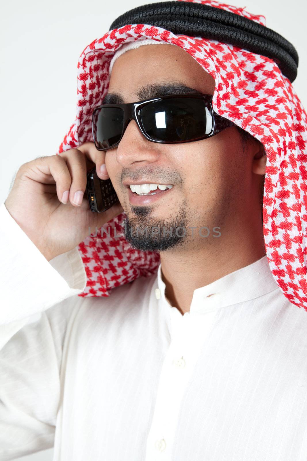 Young successful arab talking over cell phone and smiling by haiderazim