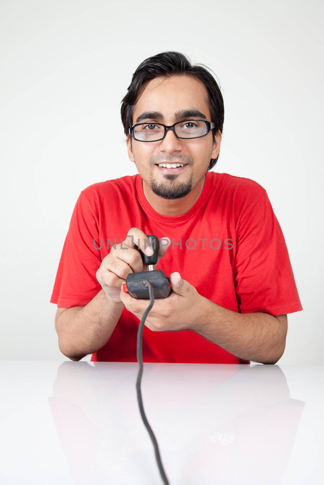 Nerd playing retro game, holding joystick by haiderazim