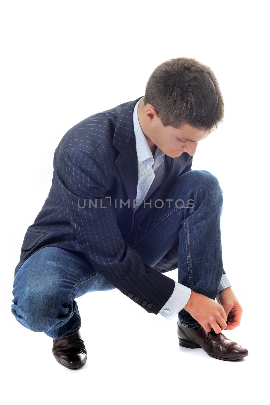 young business man lace up his shoes in front of white background