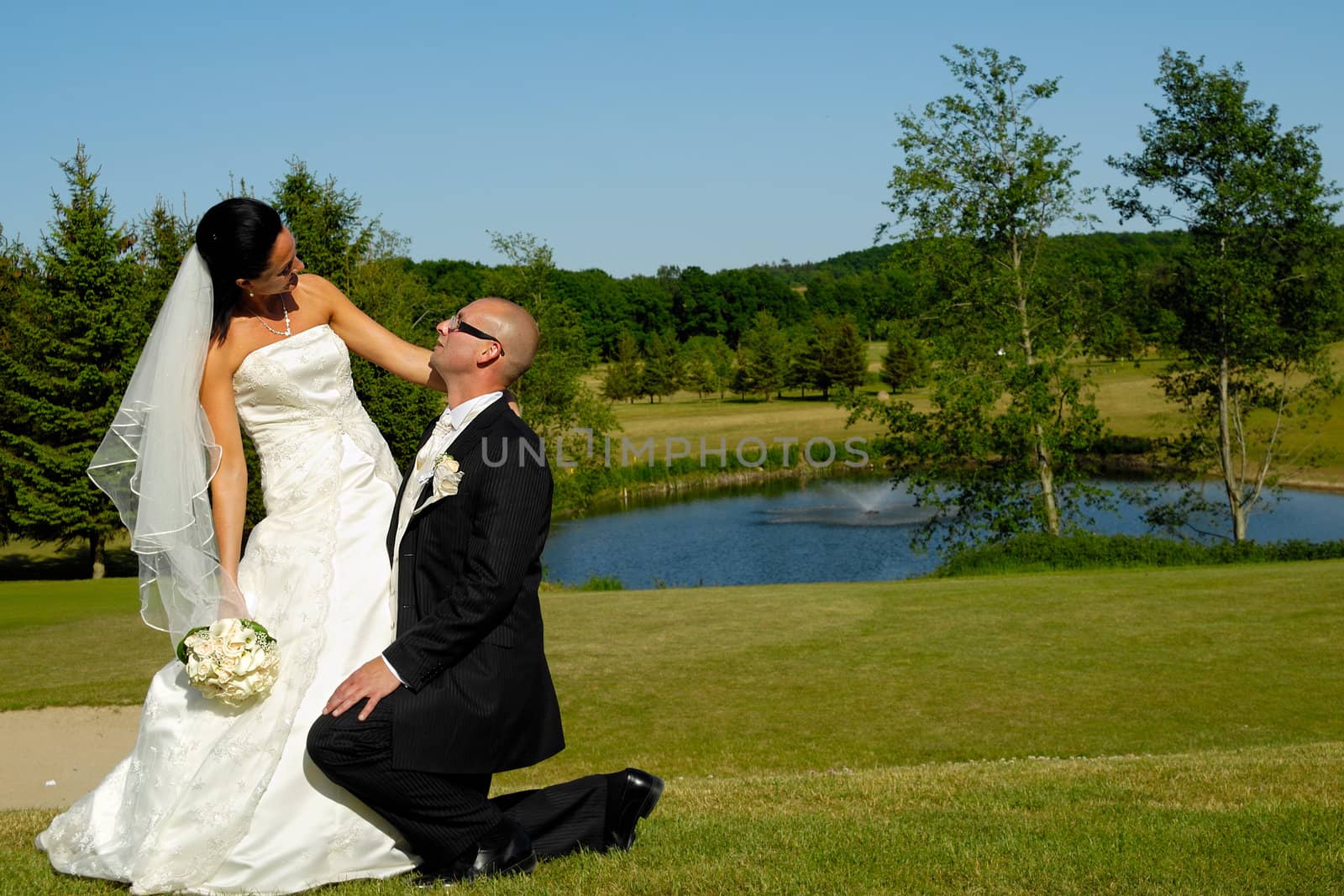 Groom is on his knee looking up at his bride