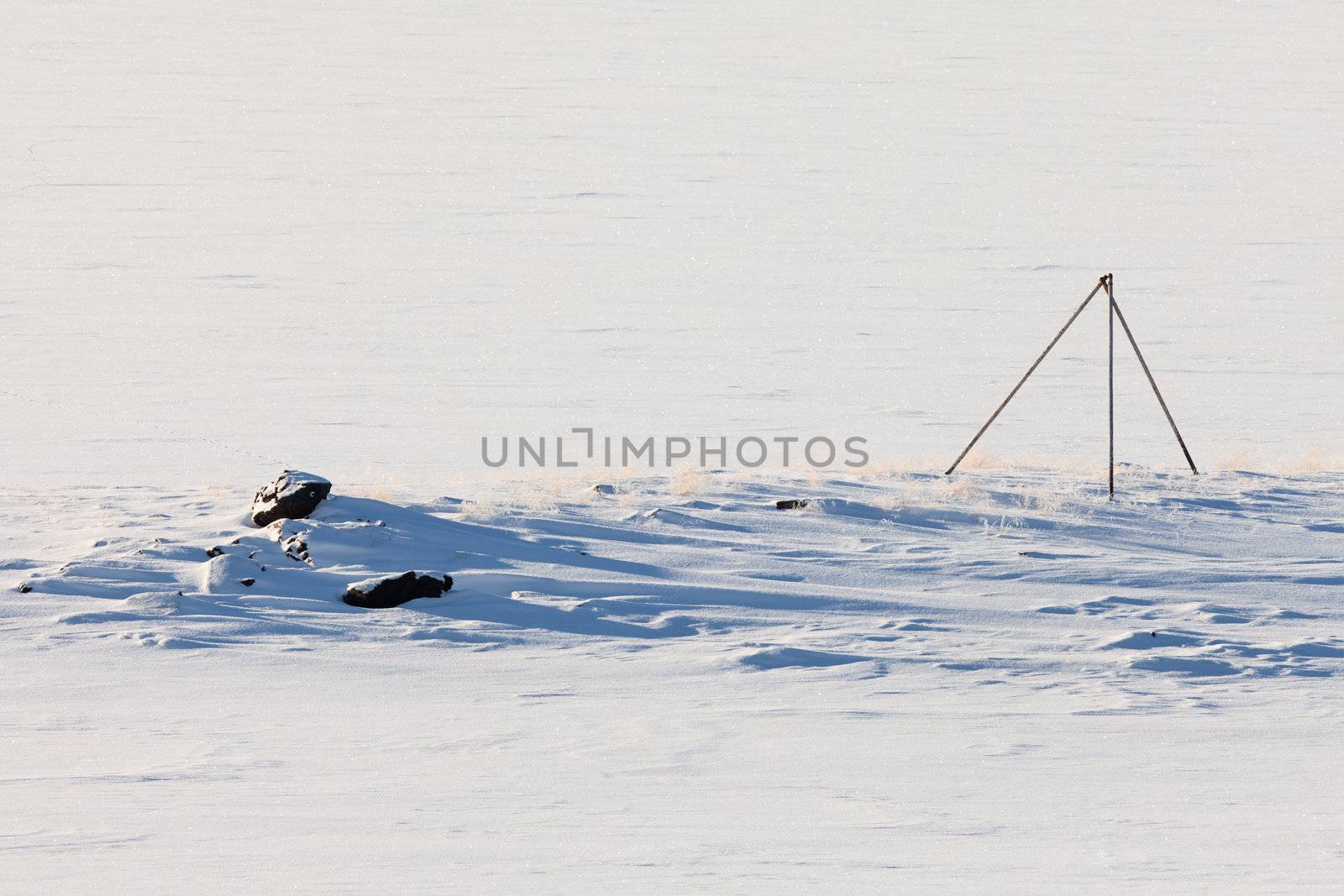 Windswept snowy landscape with orientation marker.