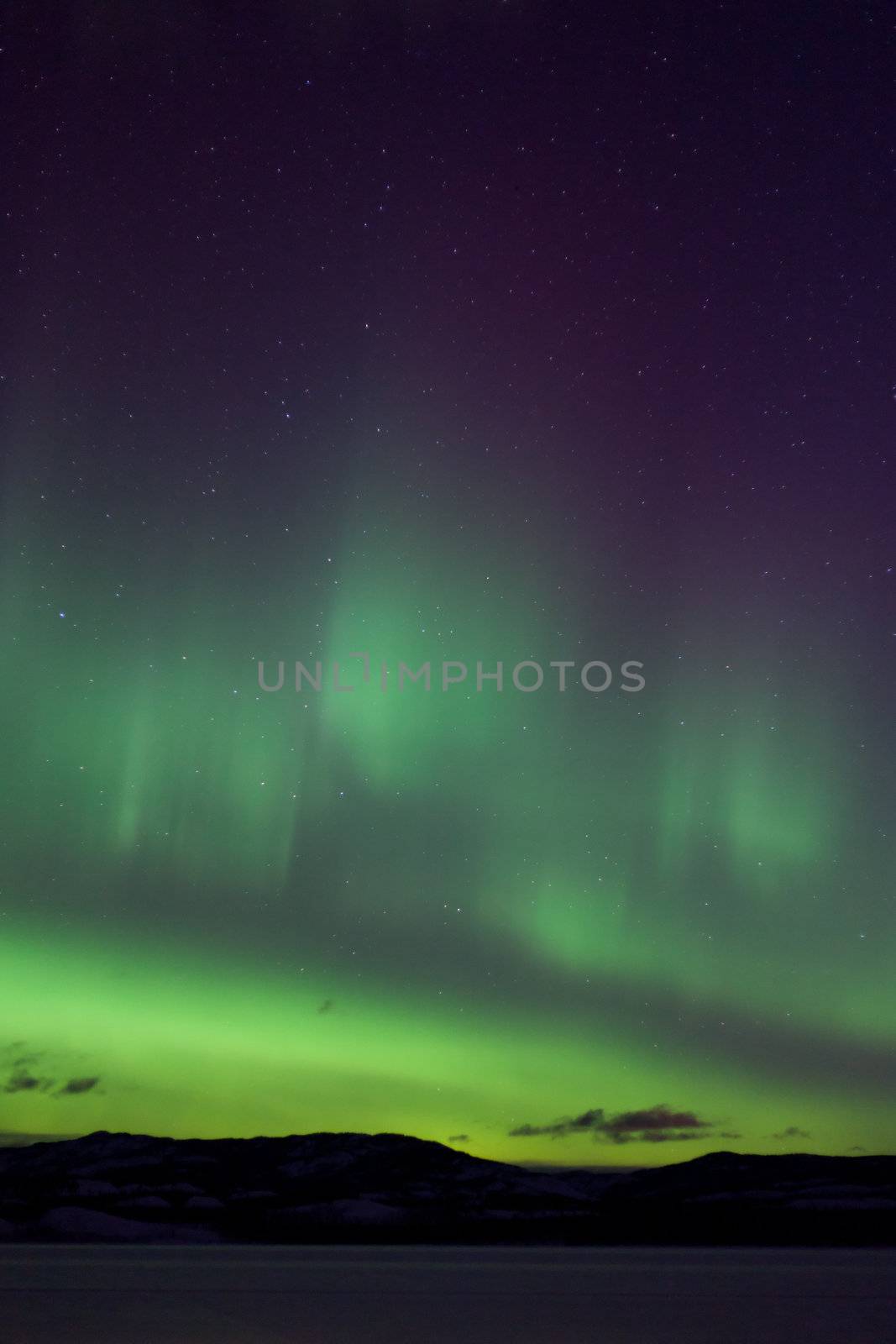 Colorful northern lights (aurora borealis) substorm on dark night sky with myriads of stars.