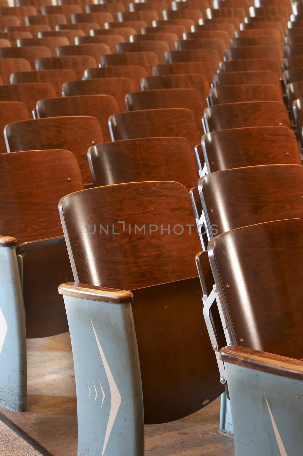 rows of wood chairs in an old auditorium