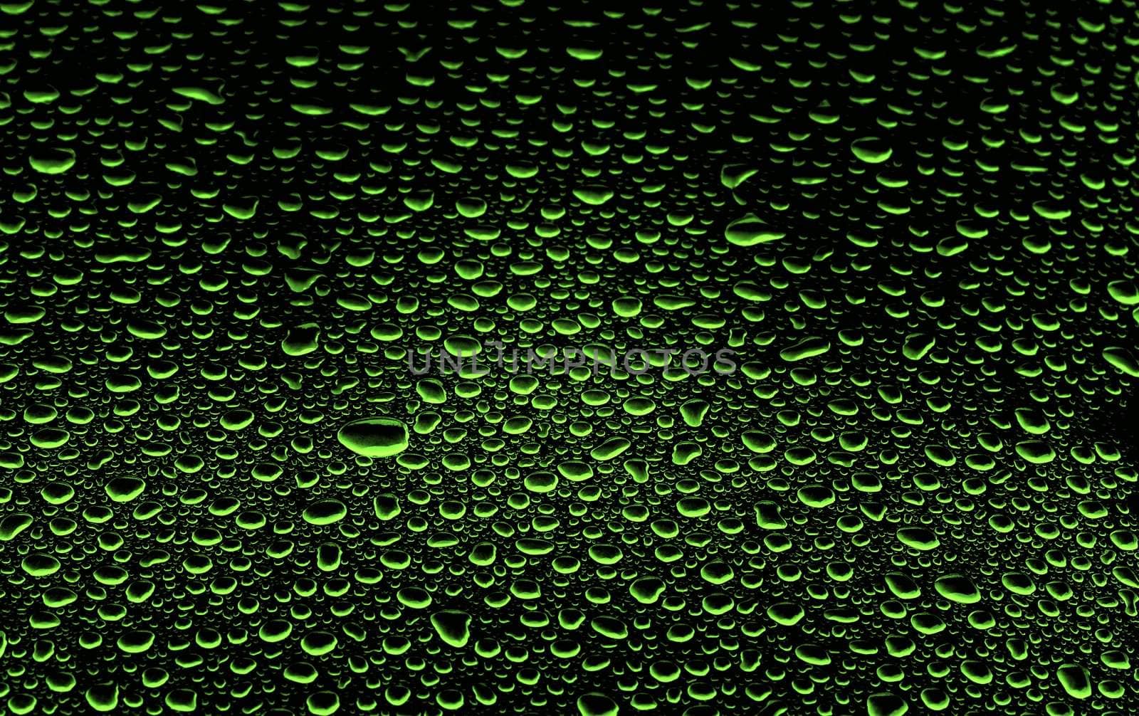 an abstract picture of green water drops on black