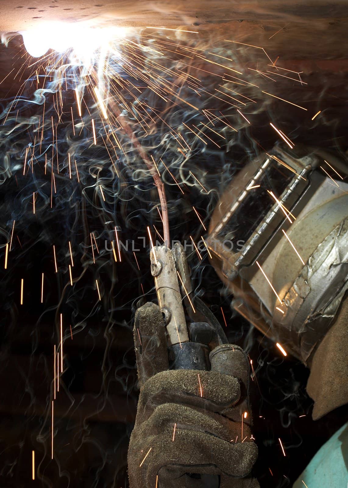 a welder working at shipyard under vessel