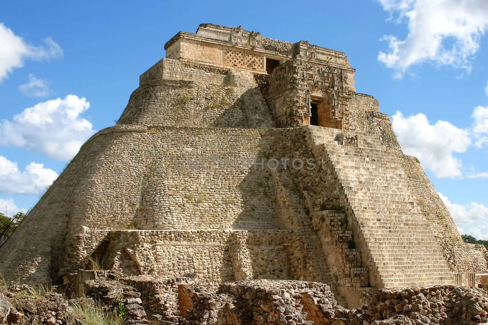 Uxmal main pyramid over blue sky with clouds