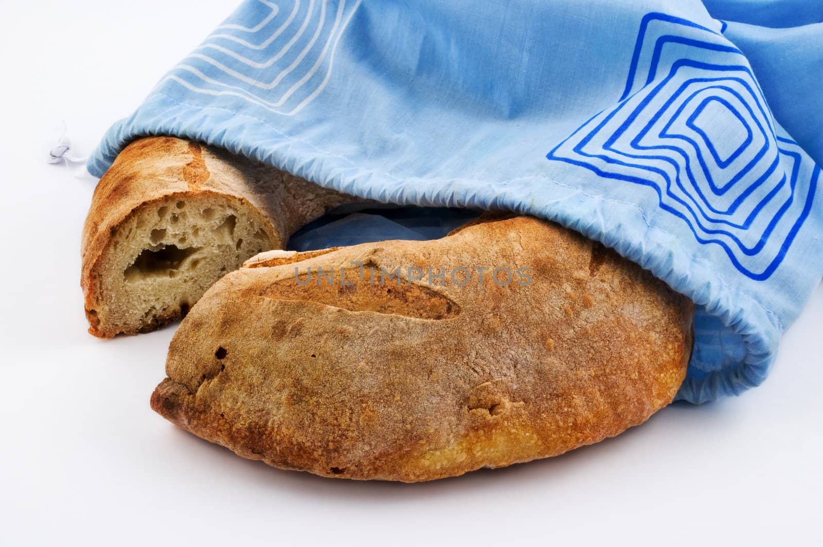 Bread loaf and blue cotton bag on white background