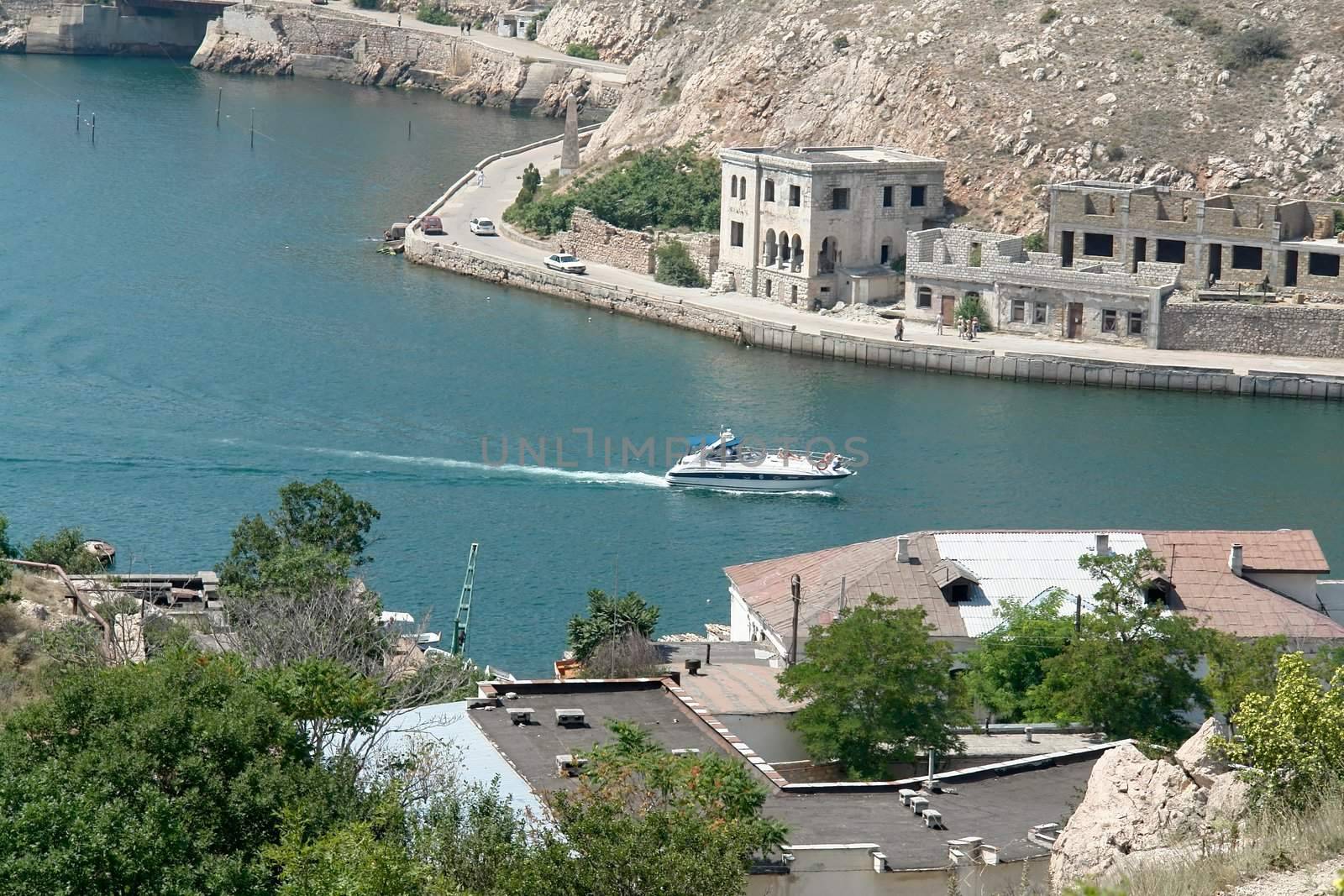 Small yacht will sail on the narrow strait in the mountains