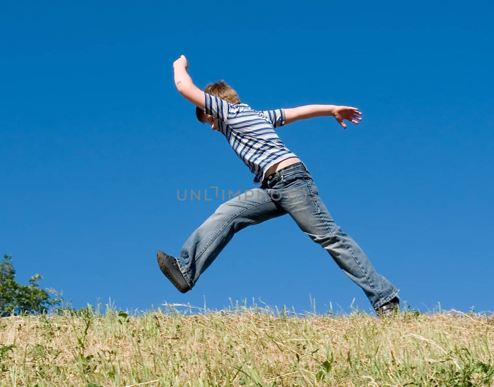 A little boy runs with sky at background