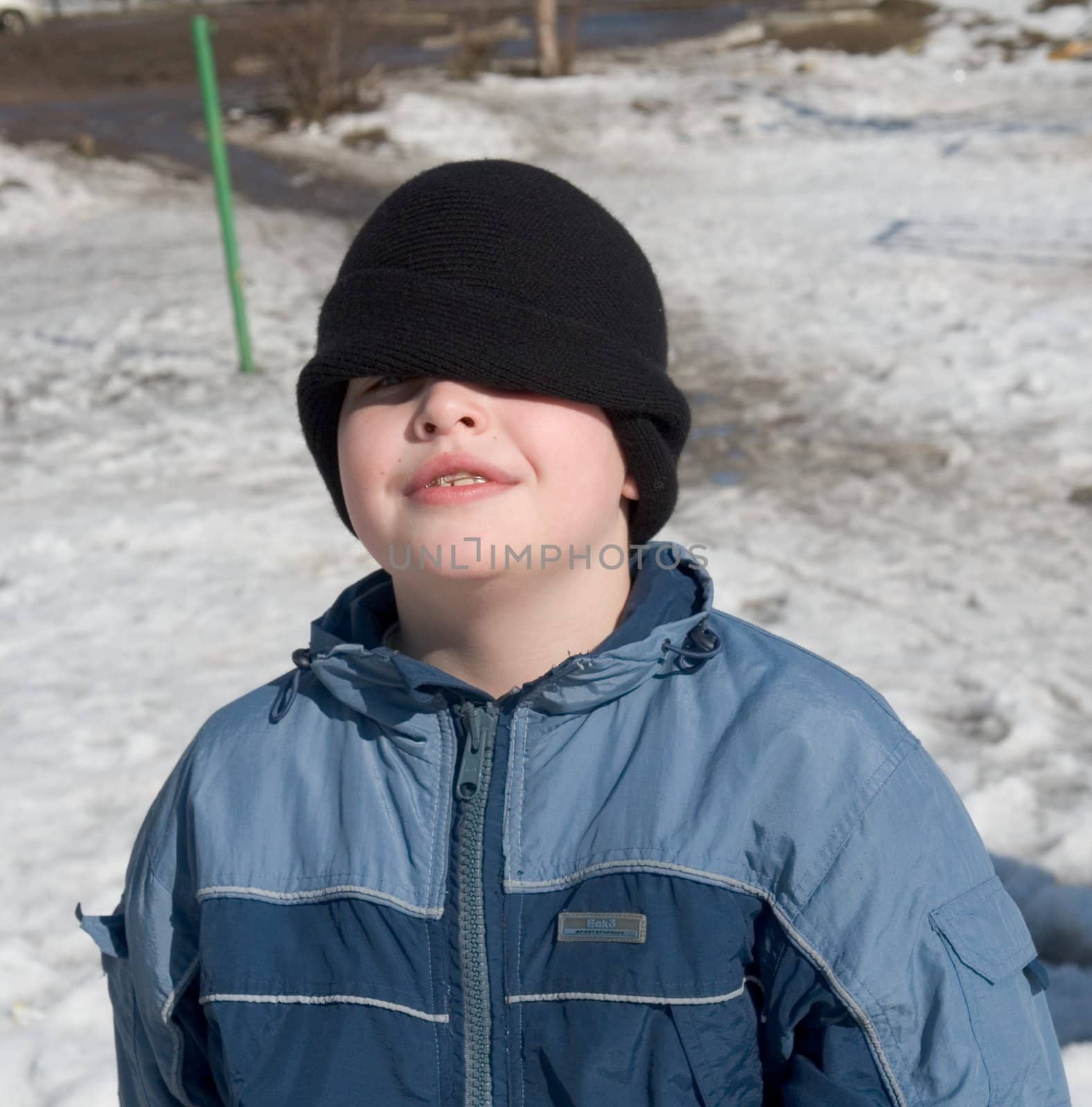 Winter. Small boy. Cap is moved to the eyes.