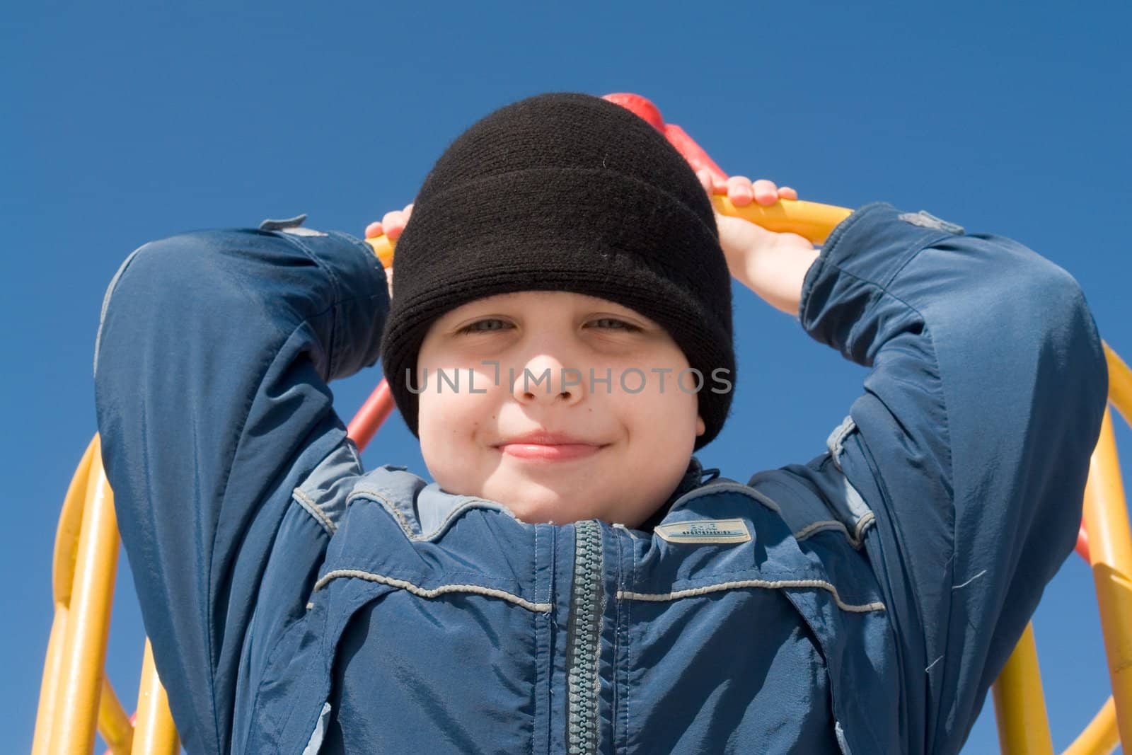 Winter. Little boy. Portrait with blue sky at background.