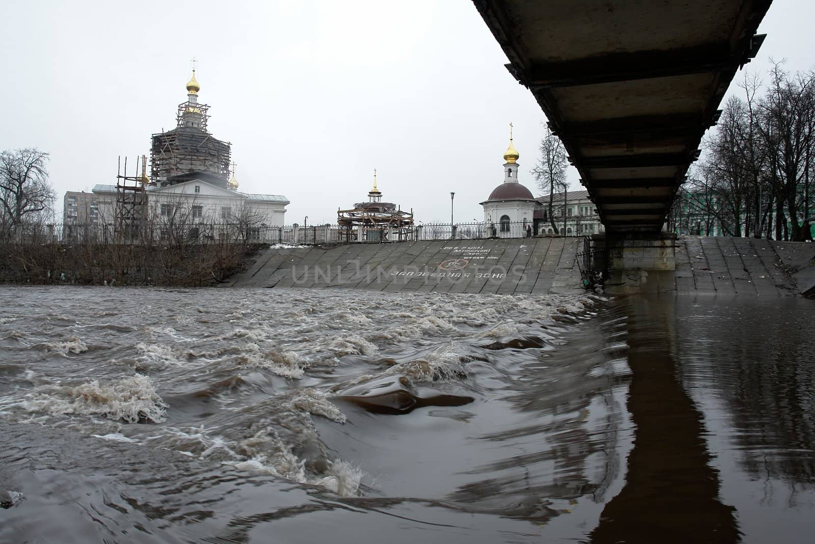 Spring tide. Orthodox church. Wiew from under the bridge.