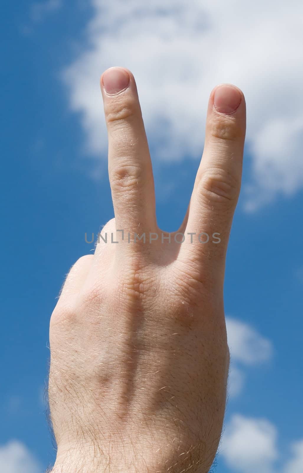 Victory sign with blue sky behind