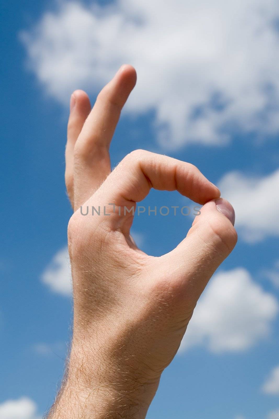 hand with symbol ok with sky at background