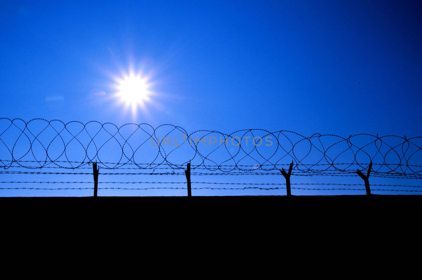 Fence with a barbed wire and blue sky