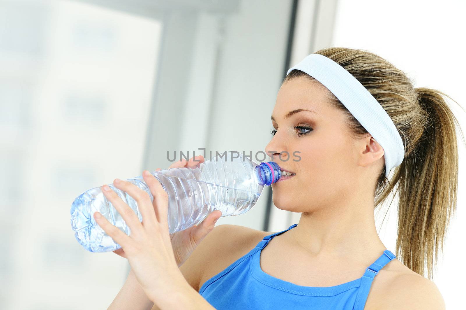 young sportive adult is drinking fresh water