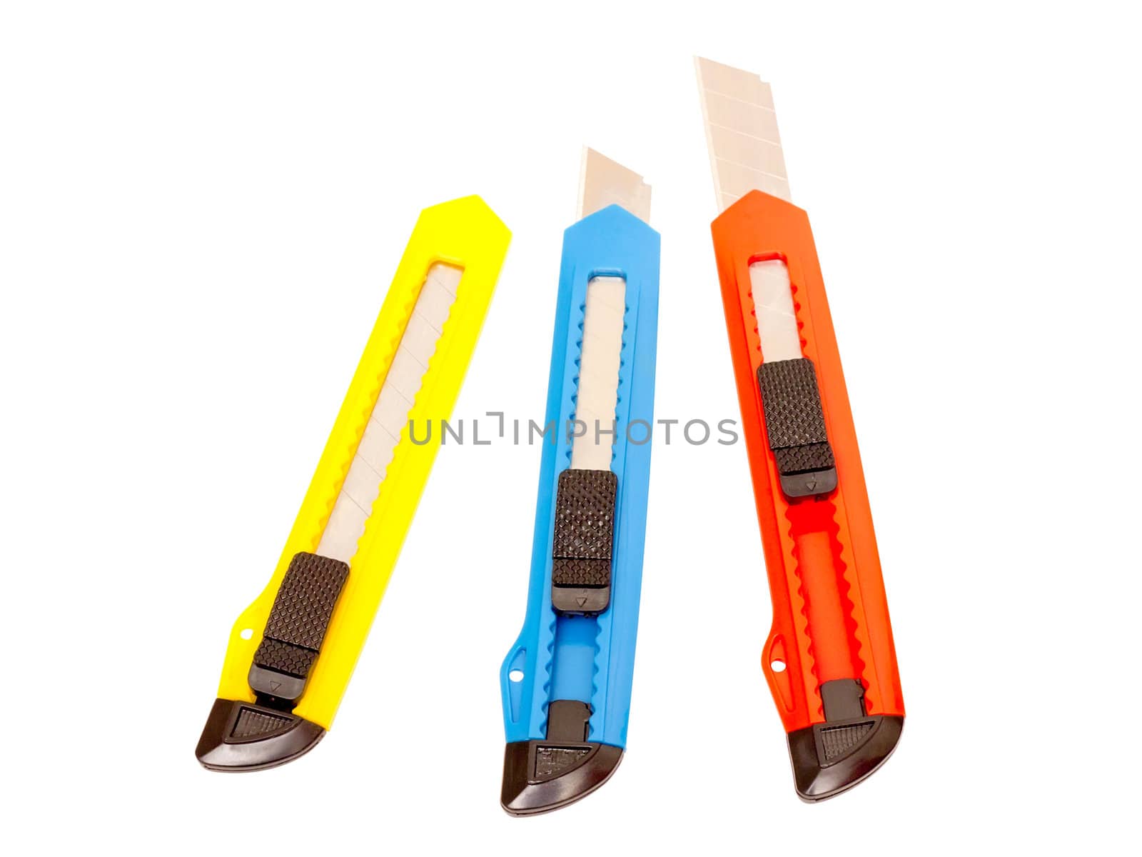 three multi-colored stationery knife on a white background