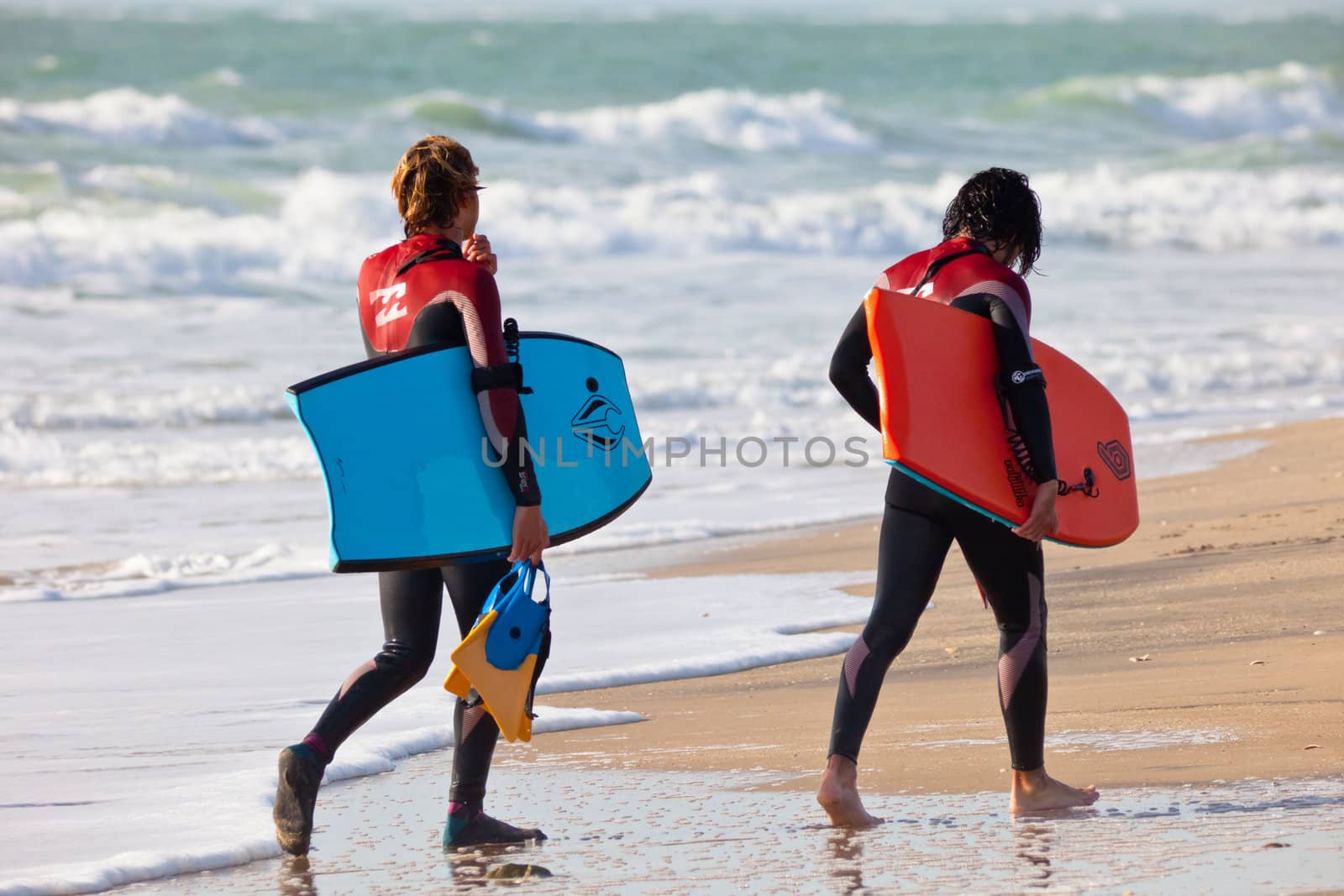 SAN FERNANDO, CADIZ, SPAIN - FEB 19: Unknown bodyboaders leaving the water on the 2nd championship of Surf and BodyBoard Impoxibol on Feb 19,2011 on the beach of San Fernando, Cadiz, Spain