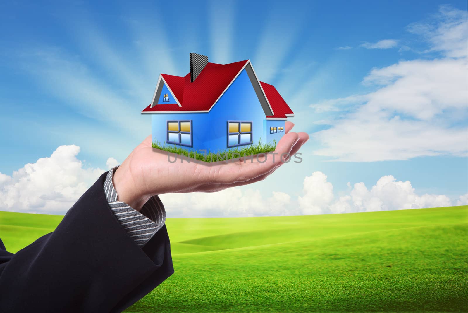 The House in the hands against the blue sky as a symbol of the real estate business.