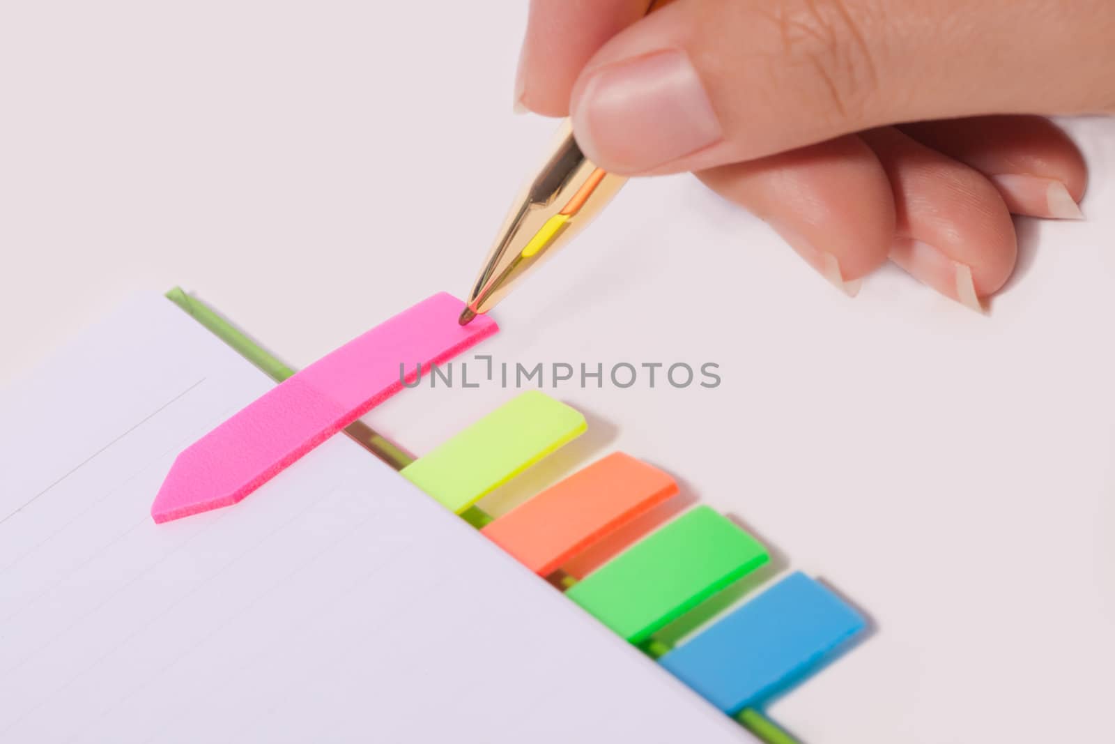 Female hand writing bookmark on notebook