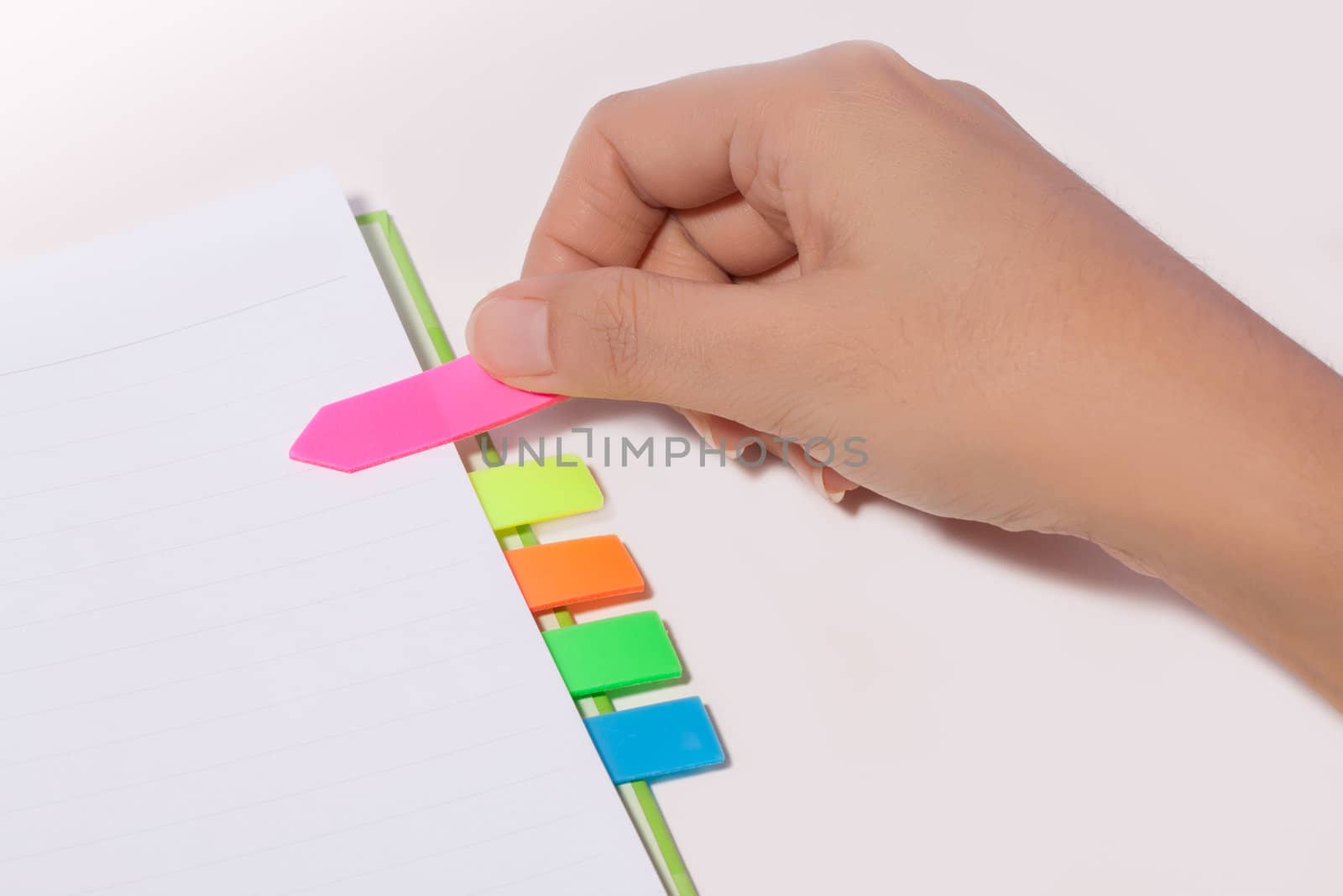 Female hand past bookmark on notebook