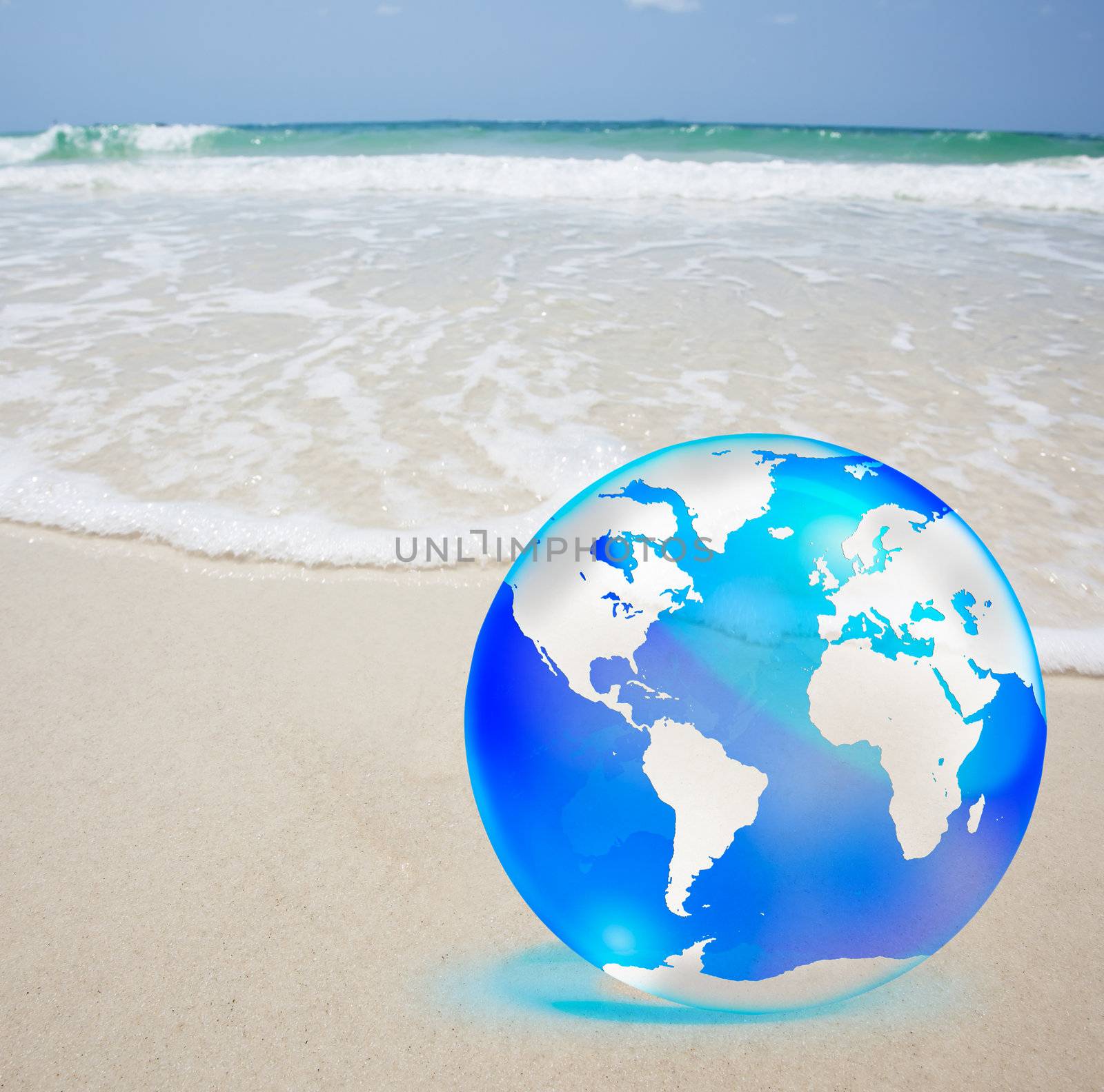 crystal globe over sand and  sea by Suriyaphoto