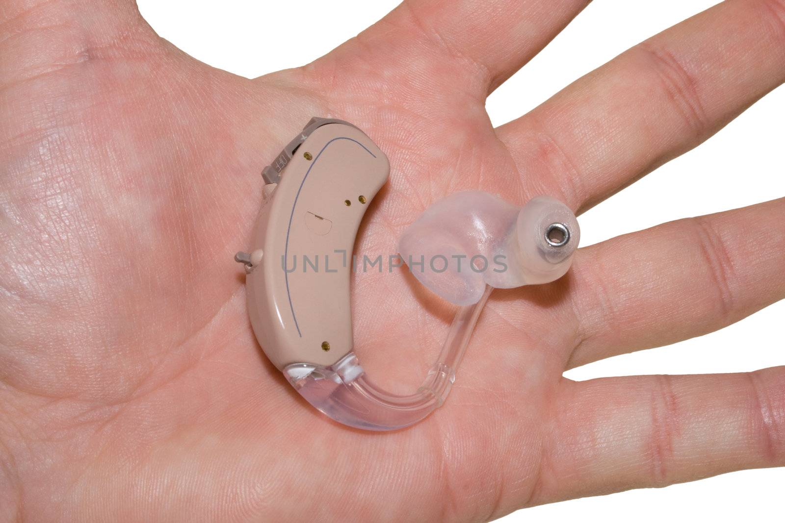 A palm holds a digital hearing aid with earmould and tubing.