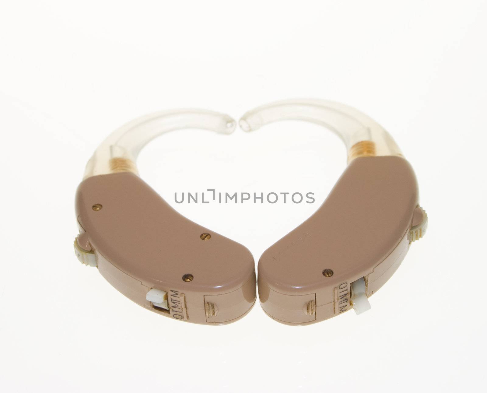 Heart shape made from two used analog hearing aids. Isolated on white.