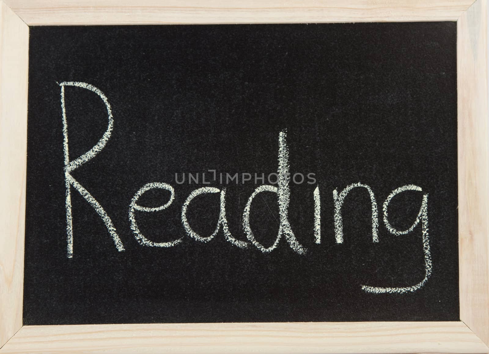 A black board with a wooden frame and the word 'READING' written in chalk.