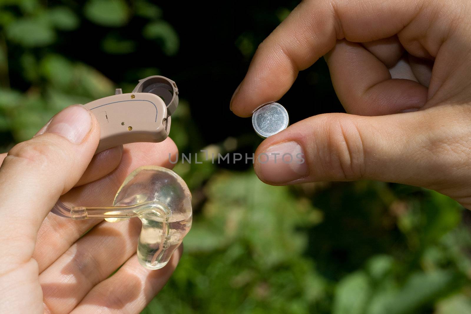 Changing a digital hearing aid battery.