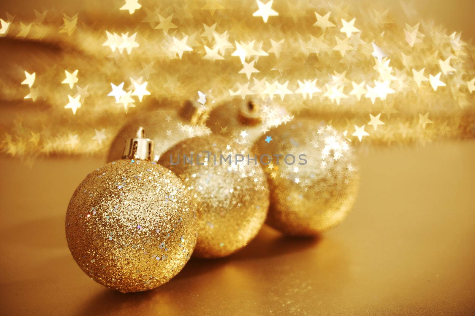 golden christmas ball on golden star bokeh background