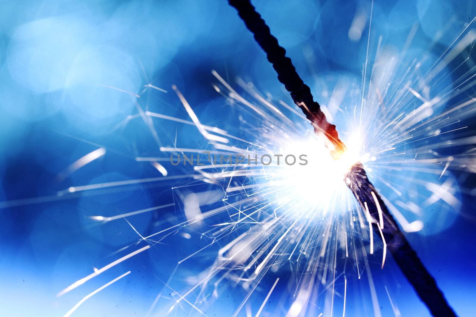 sparkler on blue bokeh background macro close up