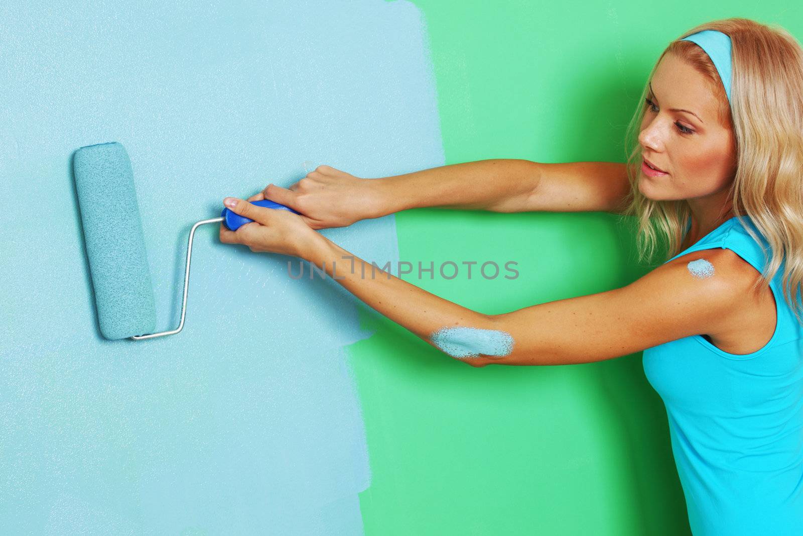 woman paints the wall roller