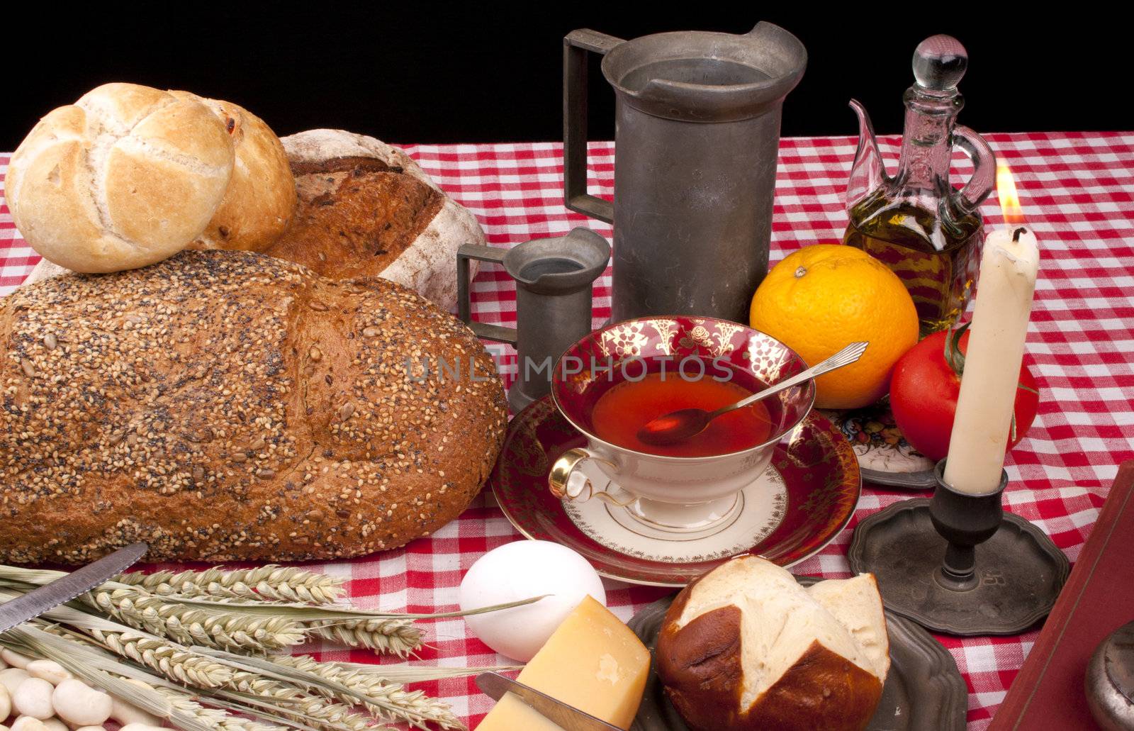 Old fashioned lunch wtih bread and buns on a table against a black background