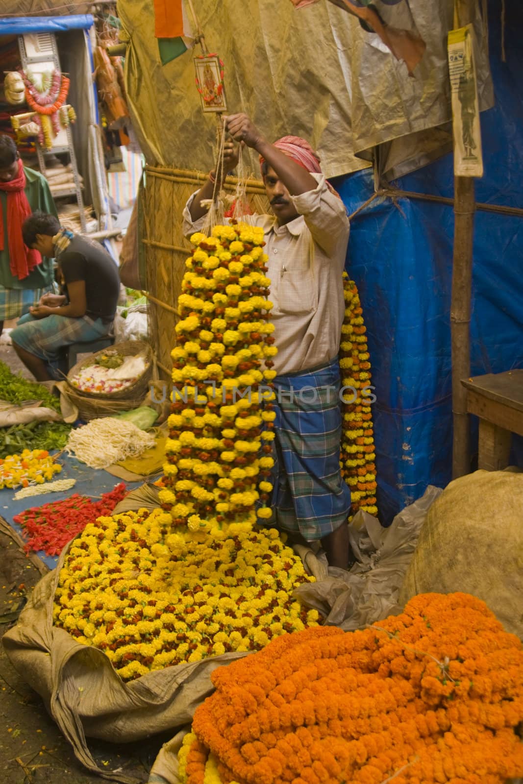 Man selling floral garlands in the flower market in Calcutta, West Bengal, India.