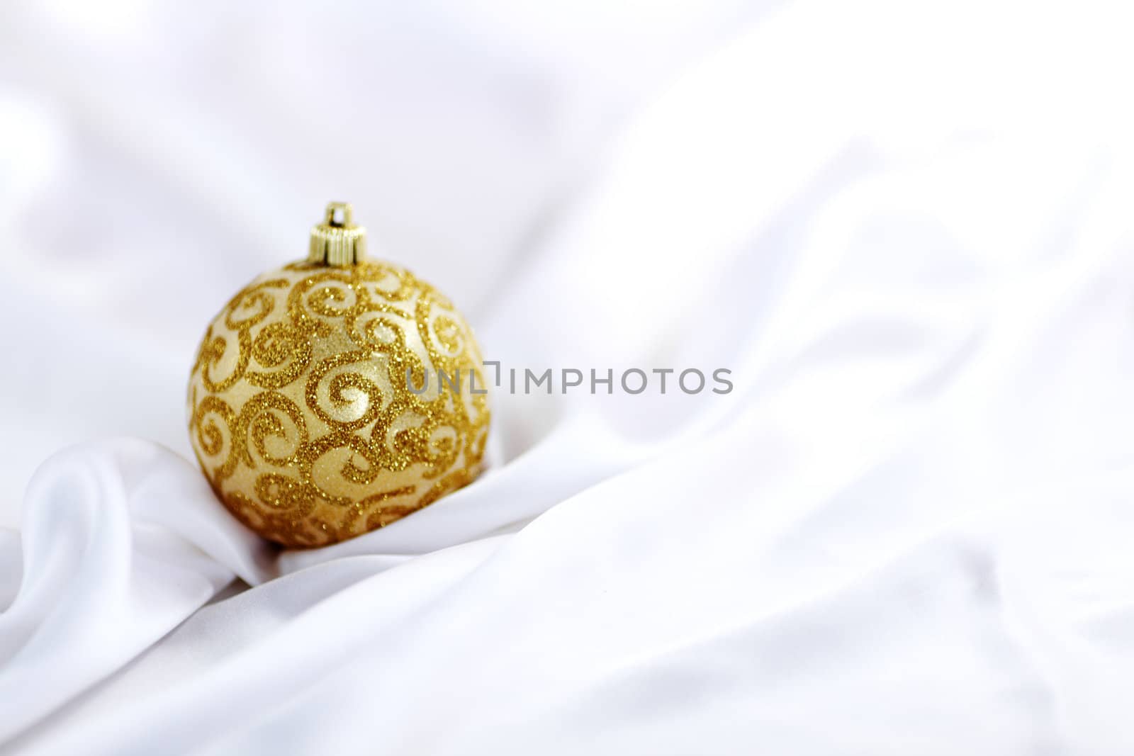  gold christmas ball on white silk