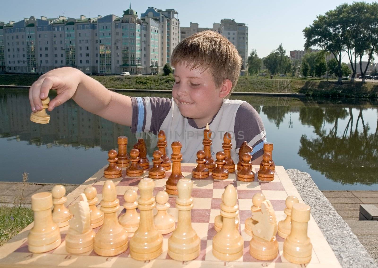 A little boy chess with river at background
