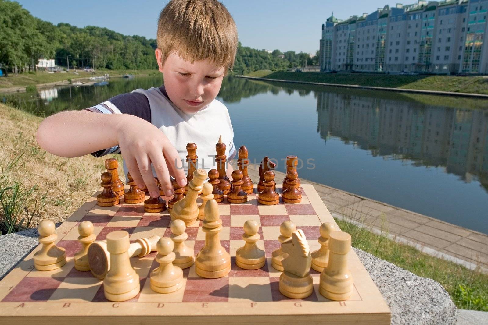 A little boy chess with river at background