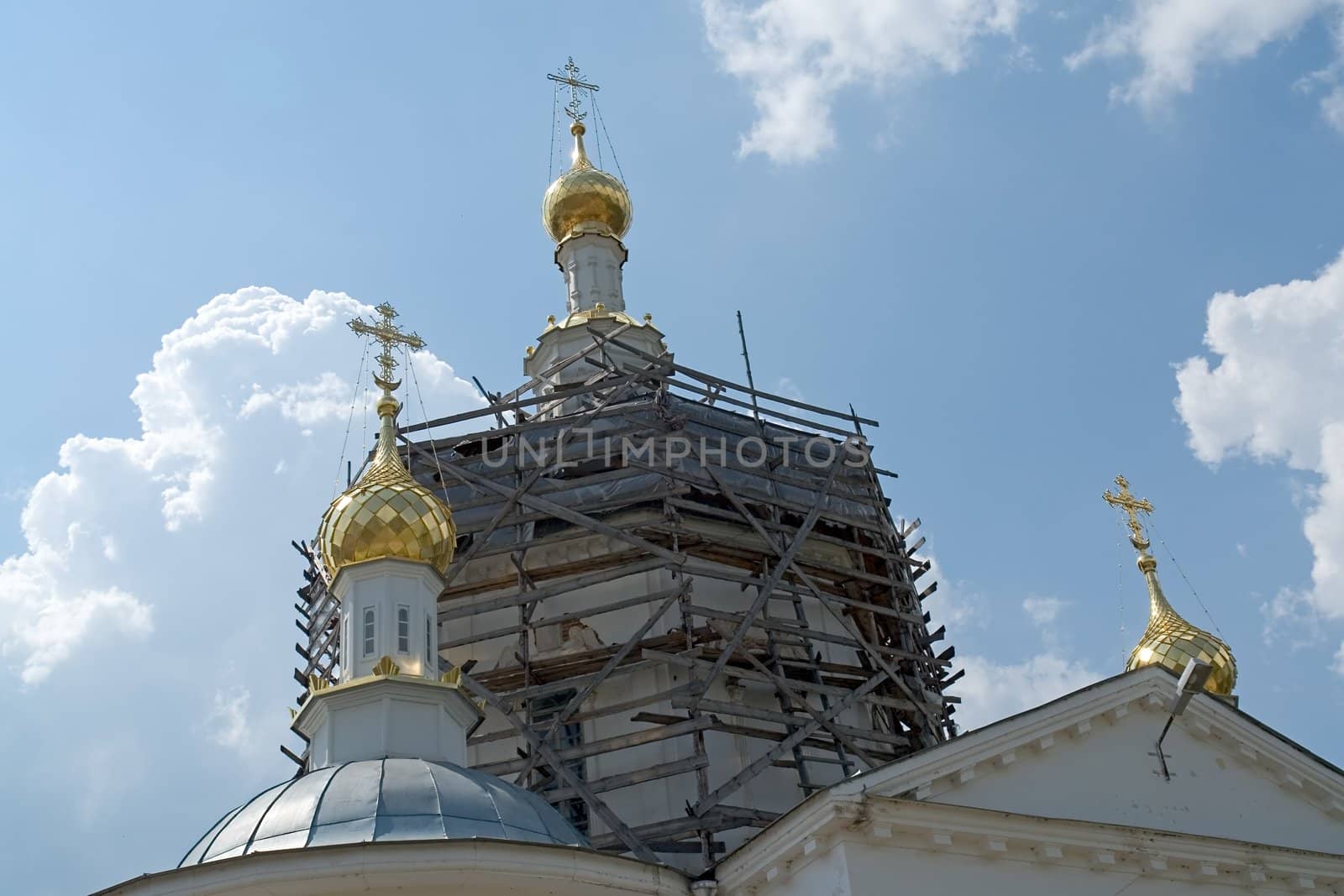 crosses on the cupolas of orthodox temple with sky at background