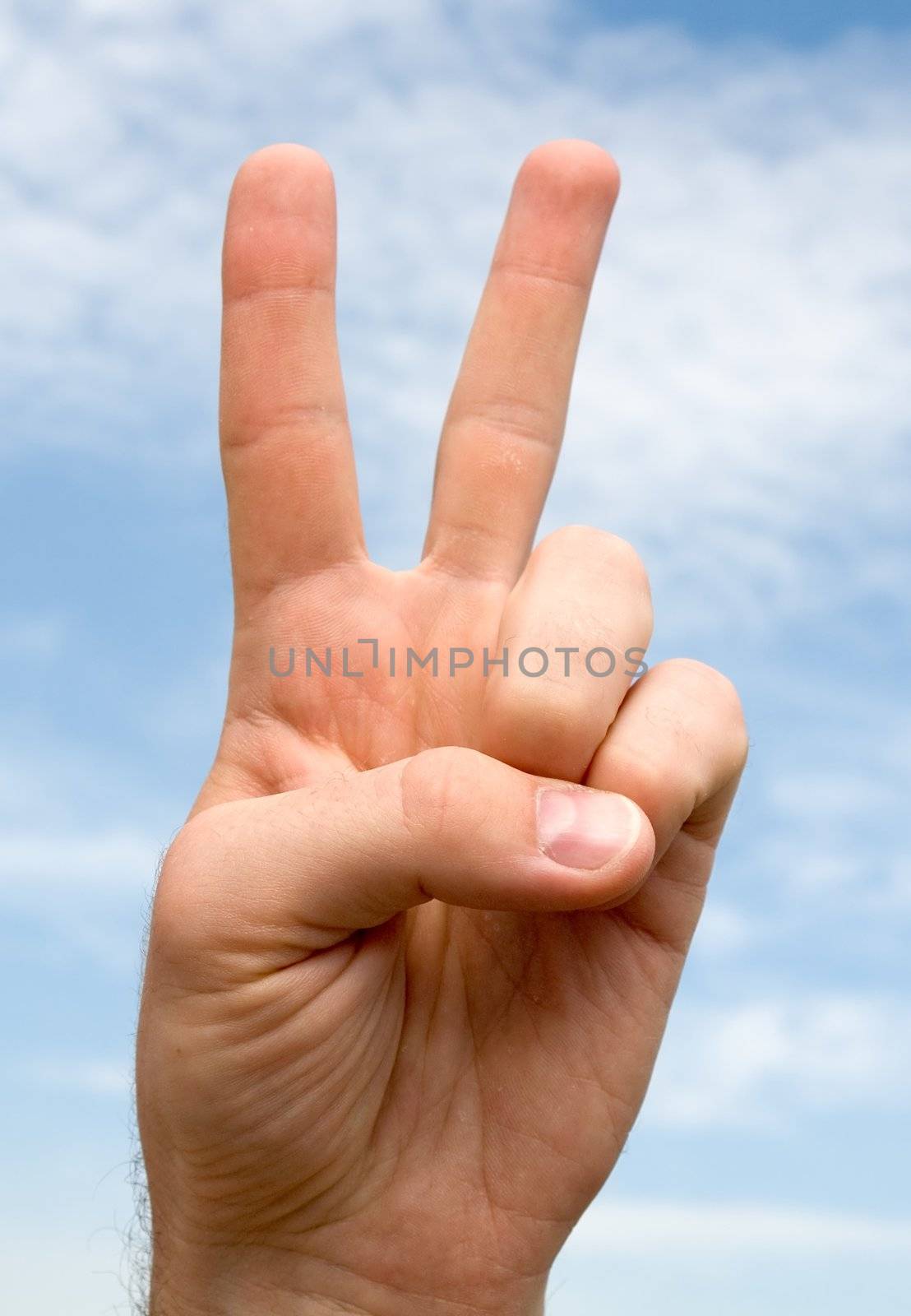 two. hand gesture with blue sky at background