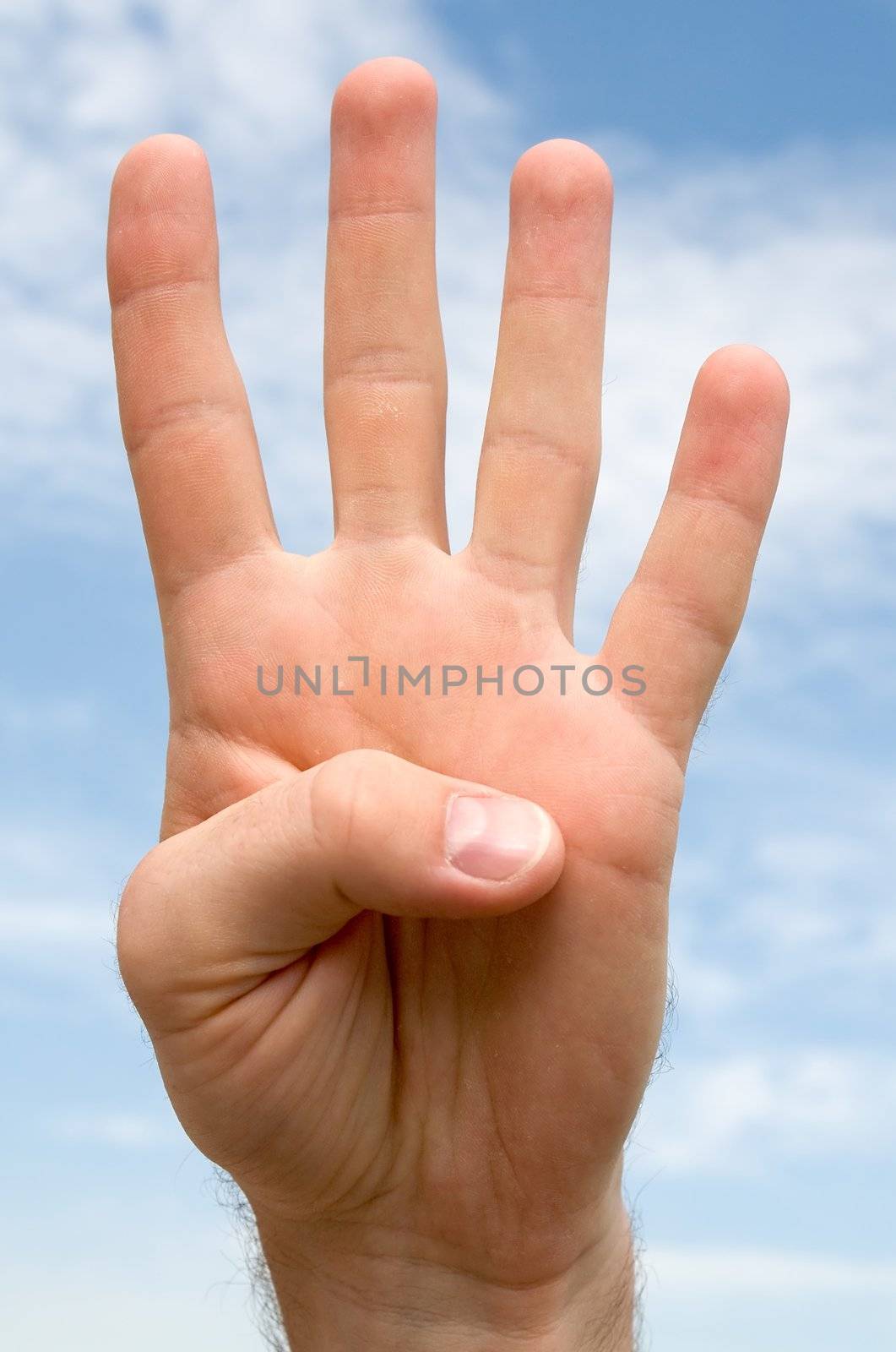 four. hand gesture with blue sky at background