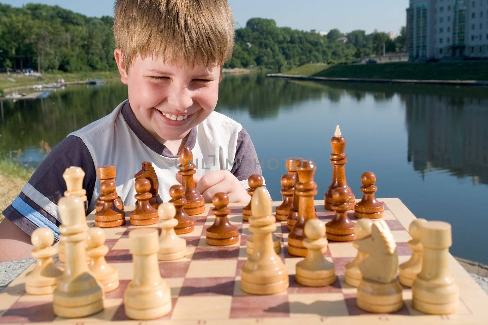 A little boy chess with river at background