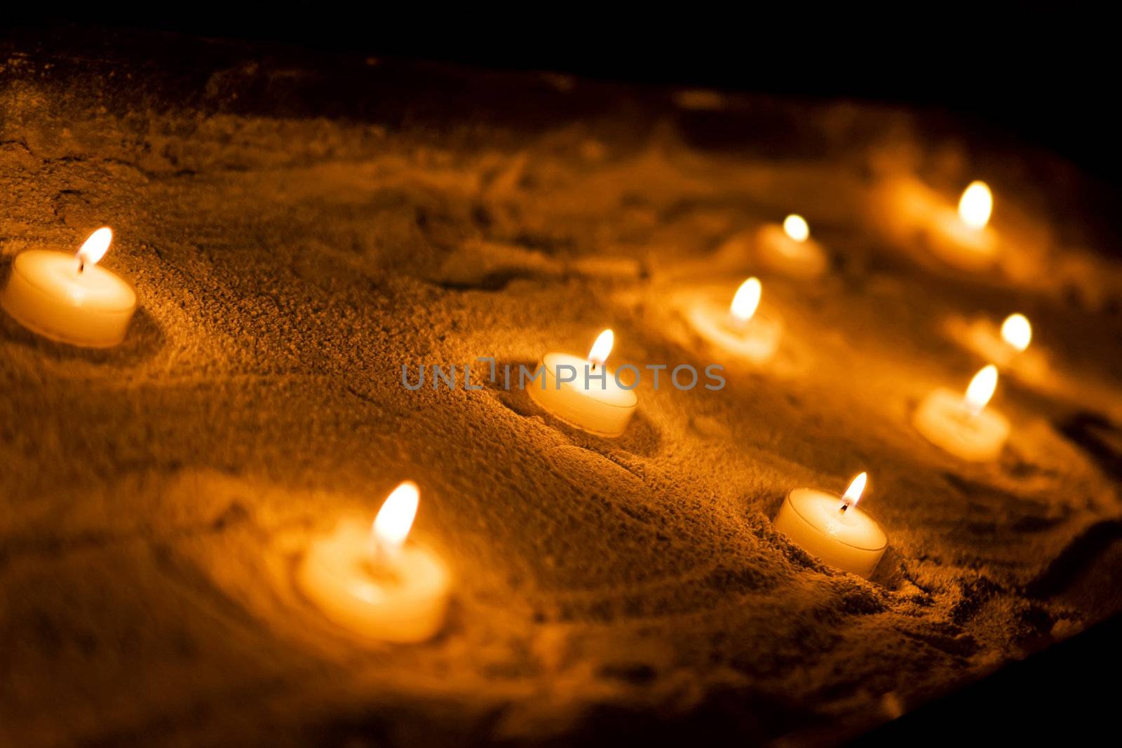 Wax sacred candles on a sand