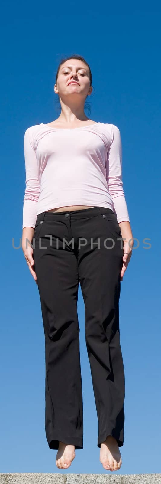 the girl jumps with sky at background