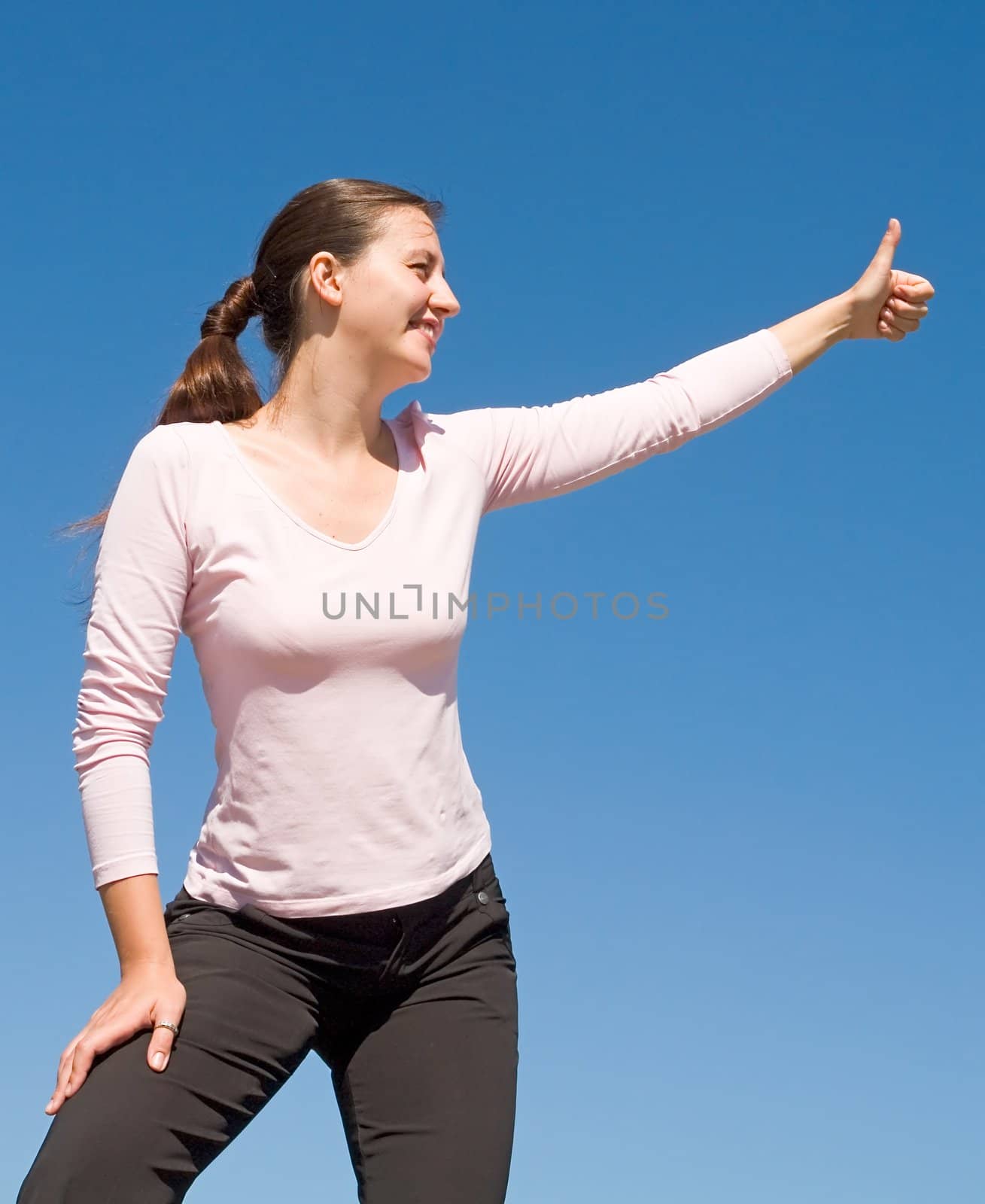 O.K. girl with thumb up on a with sky background 