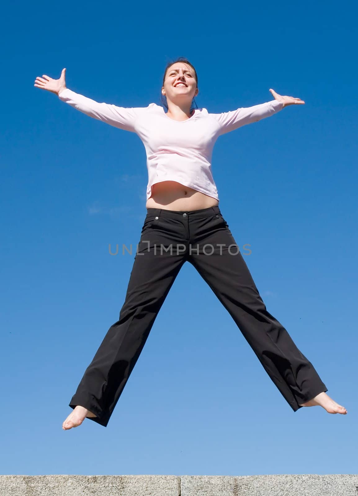 the girl jumps with sky at background