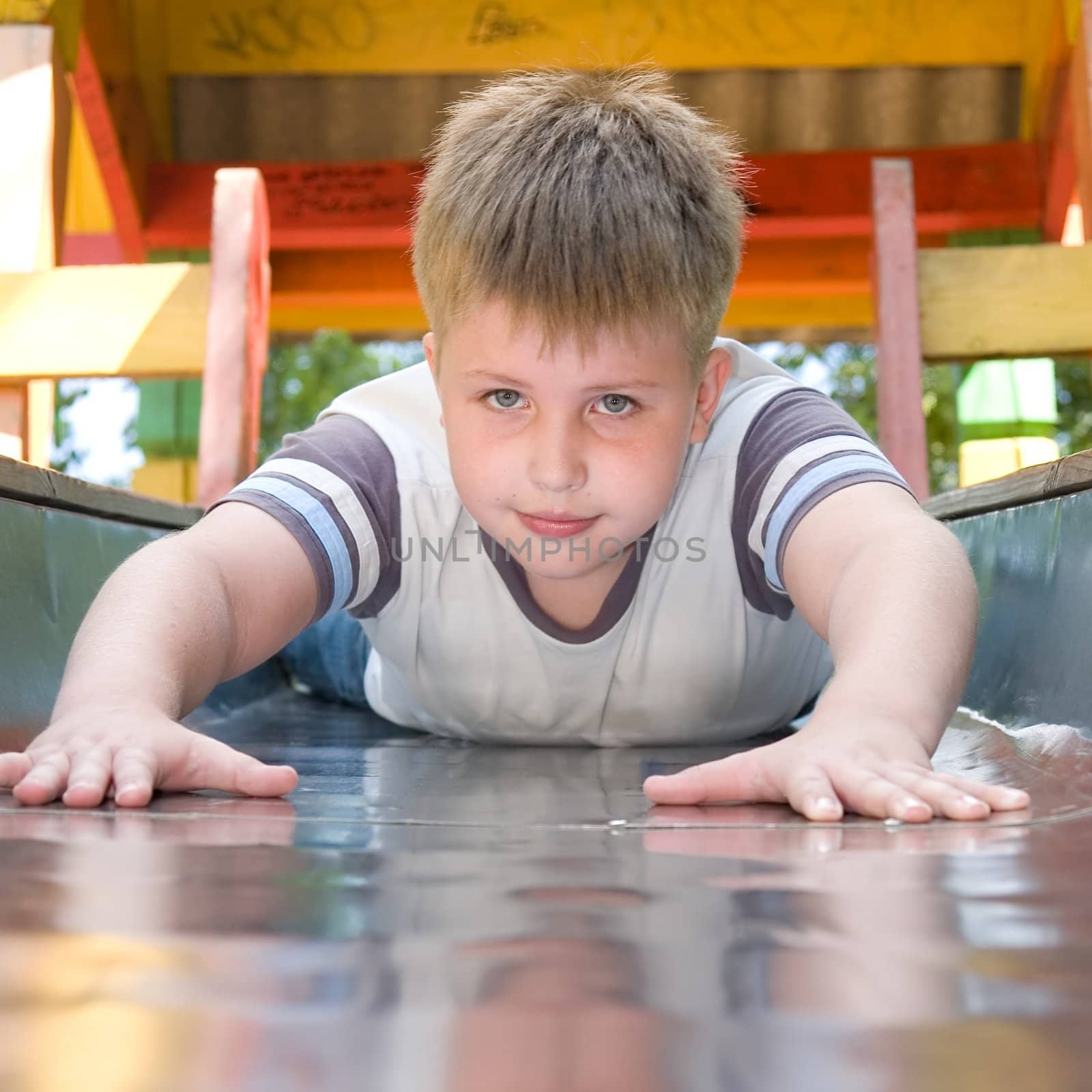 The little boy on a chute in city park