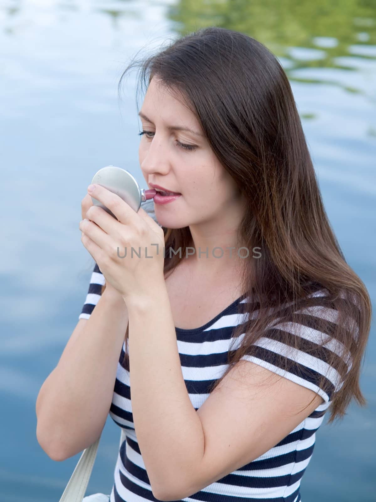 young woman put on lipstick